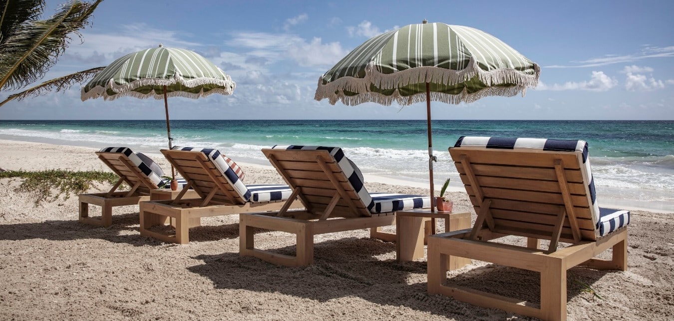 camastros de madera en la orilla del mar en tulum